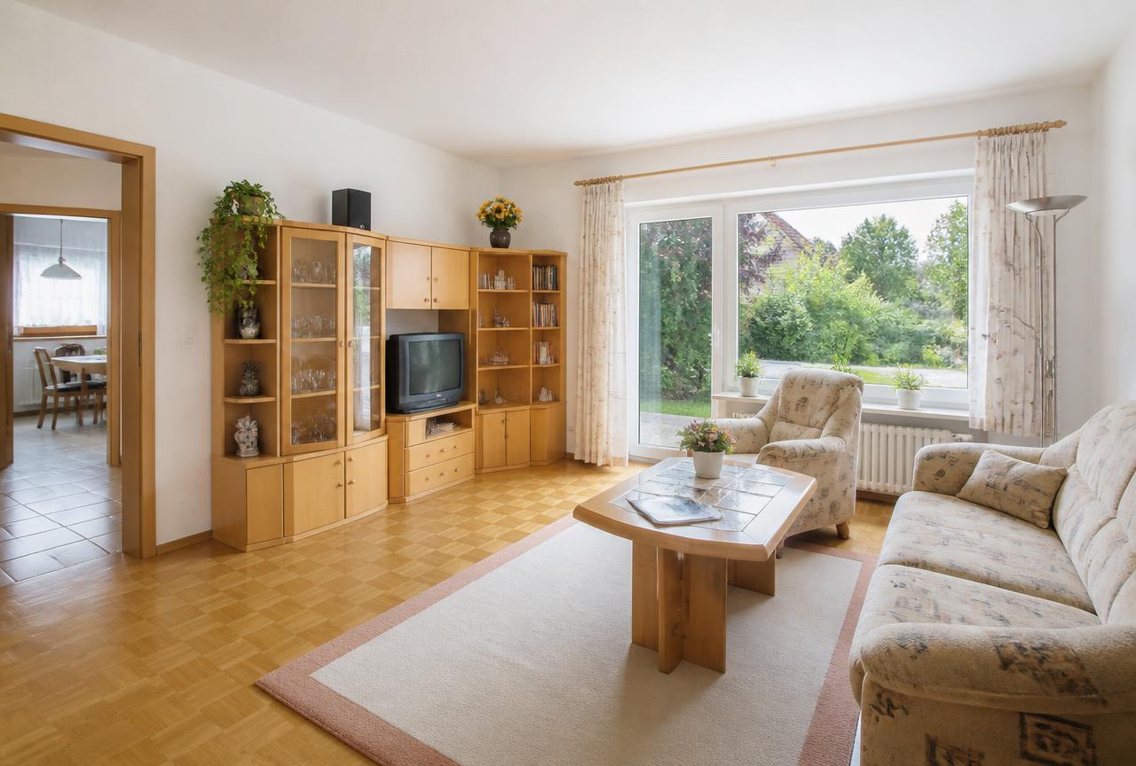 Wohnzimmer mit Parkettboden und Gartenfenster